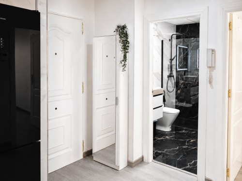 Baño moderno con ducha de mármol negro y puertas blancas en Apartamentos El Calón Playa, Cuevas del Almanzora