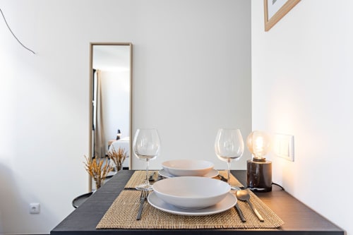 Elegant dining setup in Porto hotel Superior Studio with plated place settings, wine glasses, and ambient lighting