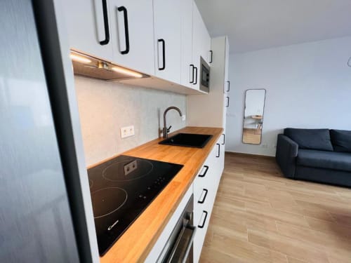 Cocina moderna con muebles blancos, encimera de madera, vitrocerámica de inducción y fregadero en apartamento El Hierro Stay, La Restinga