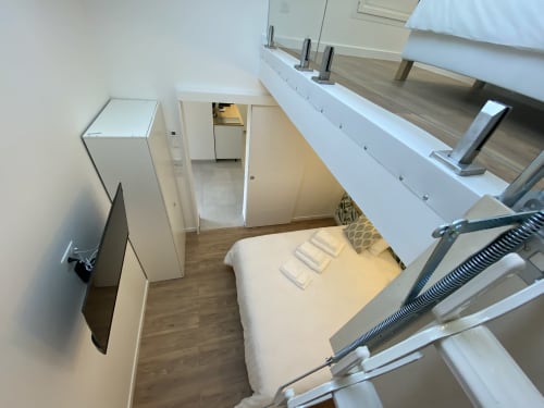 Bright apartment bedroom with loft bed, kitchenette, refrigerator, and wooden flooring at La Maison Blanche, Bouguenais