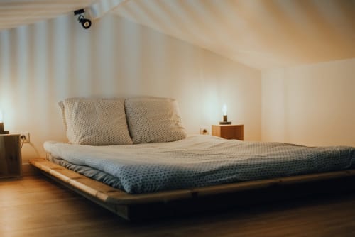 Chambre loft moderne au gîte ART DE VOYAGER à Étretat avec lit plateforme, literie neutre, parquet et éclairage tamisé