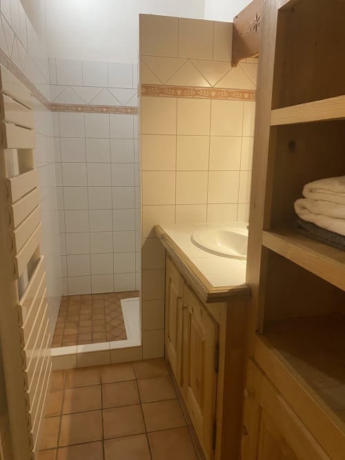 Salle de bain moderne avec carrelage blanc, meuble vasque en bois et douche à l'italienne à La Ferme des Georgières