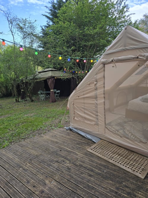 Glamping sur terrasse en bois au Domaine Trianon, Villandry, avec espace détente et guirlandes lumineuses colorées