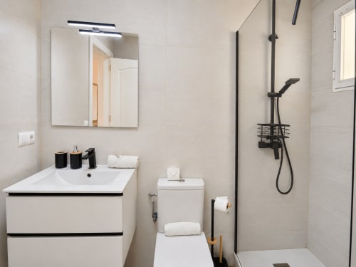 Modern bathroom in Apartamentos El Calón Playa with white vanity, toilet, and black rainfall shower system