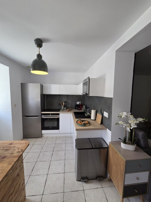 Cuisine moderne de l'appartement Little COSY à la Résidence Cosy, Saint-Méen-le-Grand, avec armoires blanches et électroménagers en acier inoxydable
