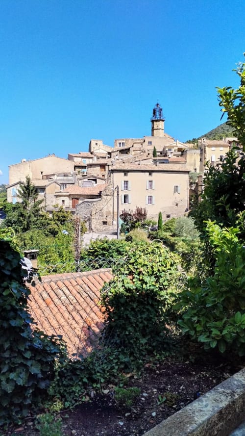 Historic stone village with lighthouse, Venterol near Nyons, South of France, viewed from villa garden with terrace and
