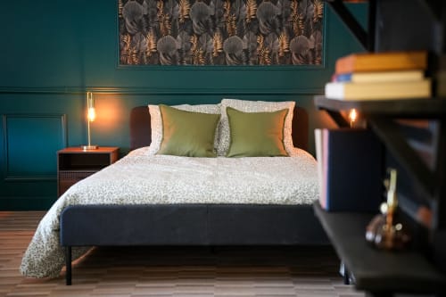 Chambre Escapade Chic aux séjours Ardennais à Renwez : murs bleu-vert, lit contemporain, coussins verts et ambiance lumineuse