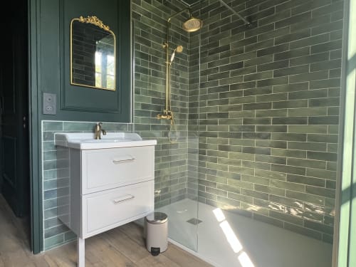 Salle de bain moderne aux carreaux métro verts, meuble vasque blanc, quincaillerie laiton et douche à l'italienne à La Millière en Vendée
