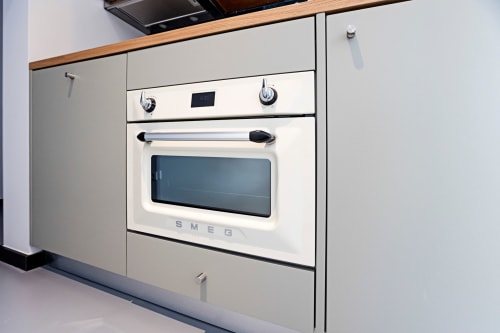 Forno e fogão SMEG na kitchenette do hotel Benefit Collection Porto com armários creme