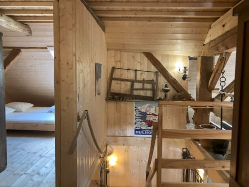 Rustic wooden cottage interior with exposed beams, loft bedroom, and mountain lodge decor at Les Chalets de l'Eau Rousse