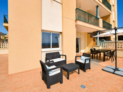 Beachfront apartment terrace with black wicker furniture and sea views at Apartamentos El Calón Playa, Cuevas del Almanzora