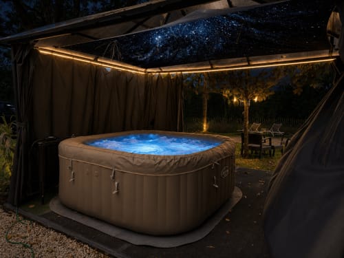 Bain à remous illuminé sous un ciel étoilé dans un pavillon couvert au Domaine Valenquercy, Le Vignon-en-Quercy