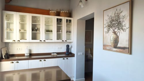 Cocina moderna blanca con encimeras de madera y armarios de cristal en el apartamento Mirador Medieval de Cáceres