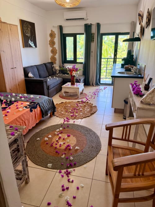 Studio de l'hôtel Le Chissioua à Sada avec vue sur mer, décoration florale pourpre et mobilier en bois