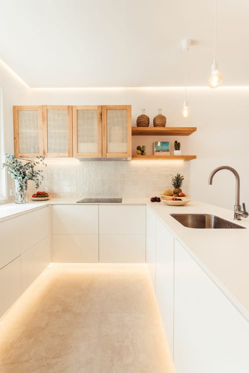 Cocina moderna blanca con acentos de madera en apartamento Cap d'Artrutx, Las Golondrinas