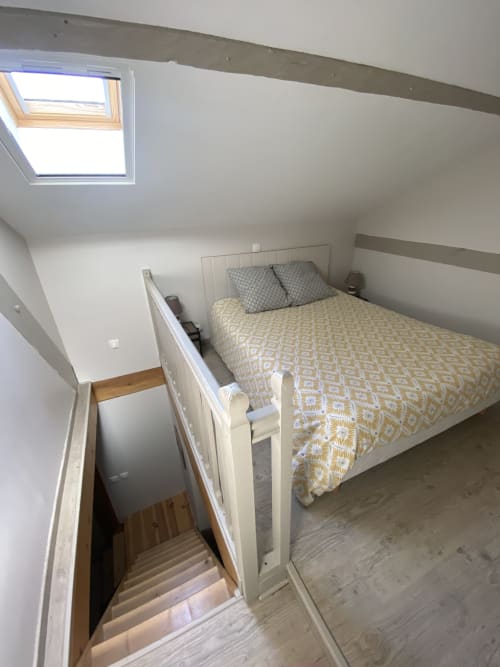Chambre cosy sous les toits avec lucarne au gîte Le Cocon De Curson, lit aux motifs géométriques