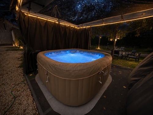Bain à remous illuminé aux eaux bleues sous un ciel étoilé au Domaine Valenquercy, Le Vignon-en-Quercy