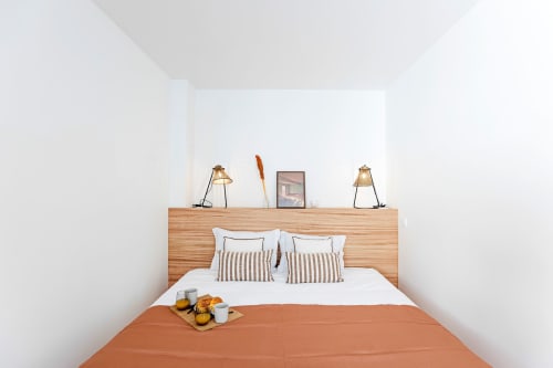 Quarto Superior Studio do hotel Benefit Collection Porto com cabeceira de madeira, almofadas listradas, manta laranja e criado