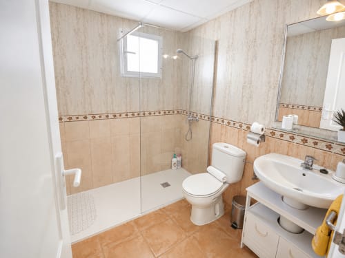 Modern bathroom with walk-in shower, toilet, and dual sink vanity at Apartamentos El Calón Playa, Cuevas del Almanzora