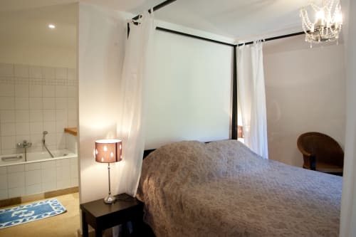 Chambre spacieuse aux Chambres d'hôtes Les Pratges à Figeac avec lit à baldaquin, salle de bain privée et équipements modernes