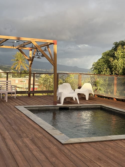 Terrasse piscine perchée à La Villa Maraloupia avec transats, pergola et vue sur les montagnes aux Avirons, Réunion