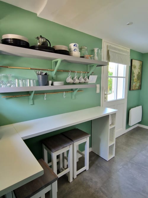 Kitchenette moderne aux murs verts, étagères blanches, tringles cuivrées et coin bar dans la Suite Familiale