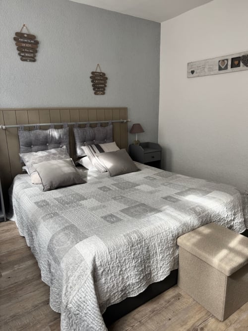 Chambre spacieuse du Paillot de Montabert à Troyes avec lit queen-size, tête de lit grise, décoration moderne et lumière naturelle