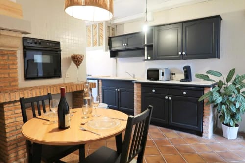 Cuisine et salle à manger modernes de l'appartement La Suite aux Gîtes Saint Valéry En Caux avec meubles noirs, carrelage en terre cuite