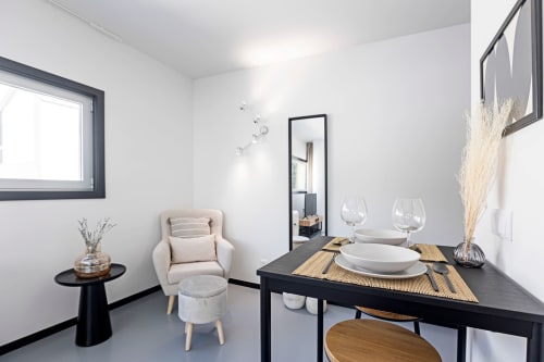 Estúdio moderno no Porto com mesa de jantar, poltrona bege e kitchenette no hotel Benefit Collection