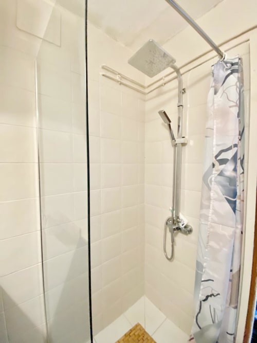 Douche moderne avec pommeau de pluie à Cayenne, carrelage blanc métro et équipements de pluie
