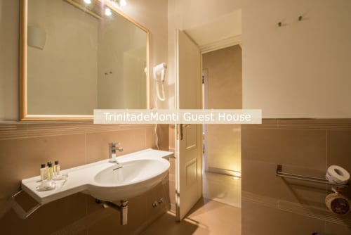 Bagno moderno con lavabo ovale alla TrinitadeiMonti Guest House Roma, con cabina doccia in vetro e specchio illuminato