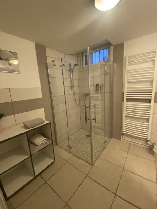 Salle de bain moderne avec douche à l'italienne, porte-serviettes et rangements au gîte Le Cocon à Chanos-Curson