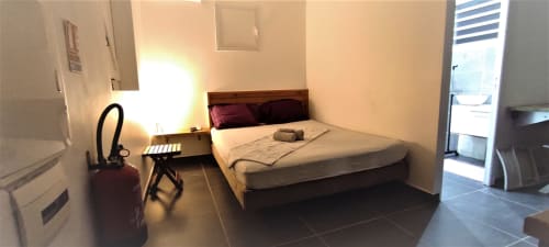 Chambre du gîte Kaz A Bibi à Sainte-Rose avec lit, bureau, climatisation, TV écran plat et lumière naturelle abondante