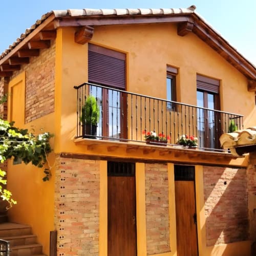 Casa colonial amarillo brillante con balcón en Cuzcurrita de Río Tirón, España