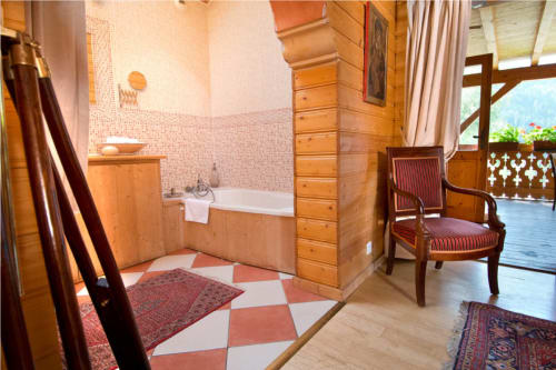 Chambre mauresque à l'Auberge Nemoz avec baignoire en bois, carrelage géométrique, vue sur les montagnes par les portes de la terrasse