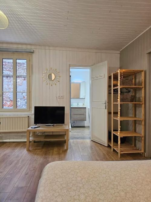 Studio moderne aux Gîtes Saint Valery En Caux avec mobilier bois, TV, kitchenette et entrée salle de bain