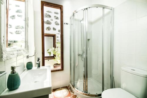 Baño moderno en Casa 1820 Rural La Palma con sanitarios blancos, ducha con mampara curva y detalles decorativos en verde