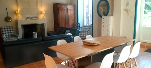 Spacious cottage dining area at Logis de Chenac with wooden table, modern chairs, fireplace, and garden views through French