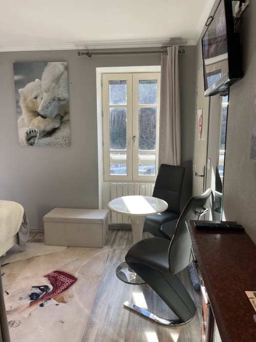 Chambre cosy à La Montagnette B&B à Moutiers avec vue montagne, TV, mobilier moderne et décoration ours polaire.