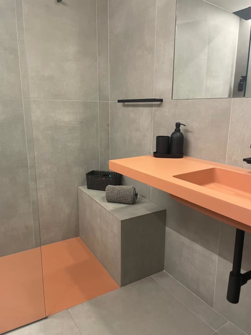 Bany modern de l'hotel L'Algars amb lavabo taronja, rajoles grisesss i accessoris contemporanis a Tarragona