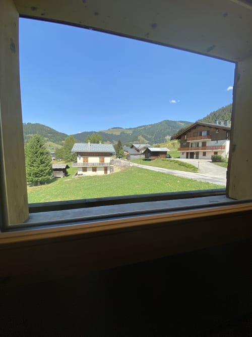 Mountain valley view from apartment window at La Ferme des Georgières, Notre-Dame-de-Bellecombe, with Alpine chalets and