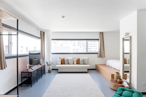 Estúdio superior moderno no Porto com cama, sofá, kitchenette, vista para a cidade e mobiliário contemporâneo