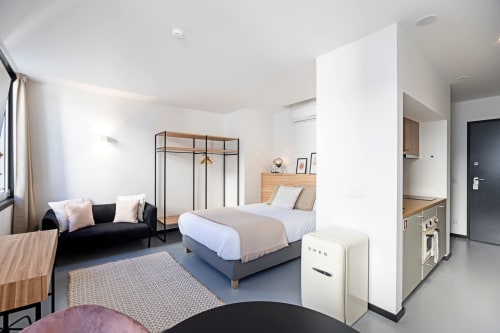 Estúdio moderno no Porto com cama, sofá, cozinha americana e vista para a cidade da Benefit Collection