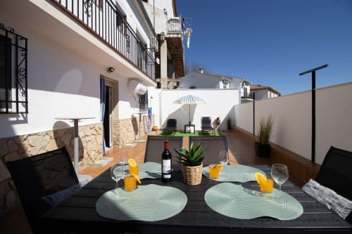 Comedor en terraza de la casa rural La Casa de Tita Clota en Setenil de las Bodegas con mesa puesta para dos personas