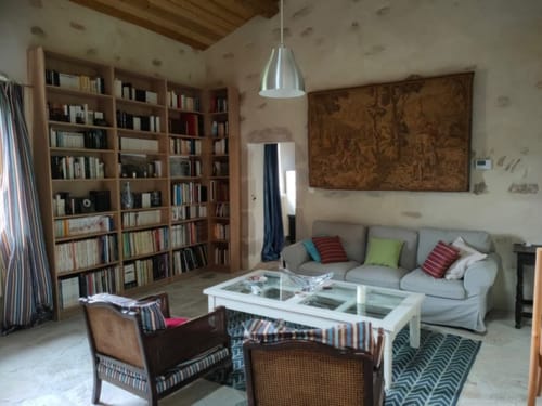 Spacieux séjour avec canapé gris, bibliothèques en bois et mobilier moderne à la Magnanerie de Sainte Croix