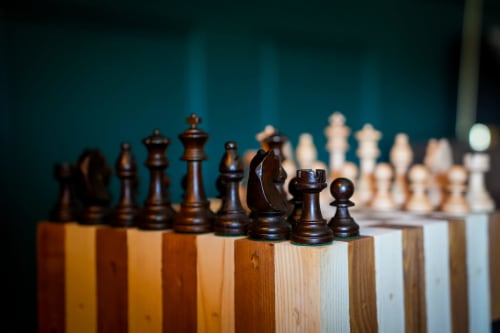 Pièces d'échecs en noir et blanc sur plateau en bois aux Séjours Ardennais, Renwez