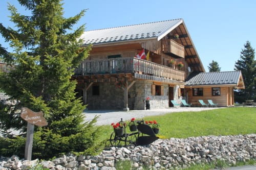 Chalet La Louvière mountain lodge in La Toussuire with wooden architecture, metal roof, and alpine surroundings