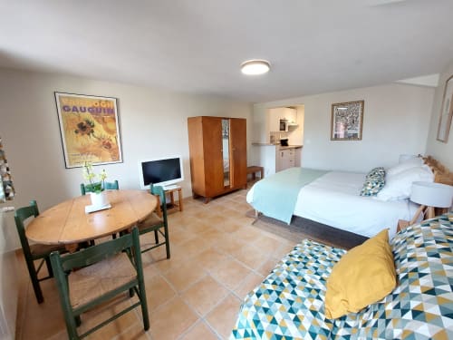 Sunflowers cottage studio at Les Gites de Campardon with two beds, dining table, kitchenette, TV, and garden view in Monties,