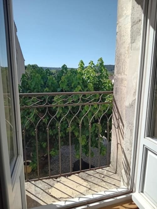 Vue du jardin depuis le balcon de la Suite à Chez Laure & Marc, Plaissan, avec balustrade ornementale surplombant de magnifiques vignobles et la campagne environnante