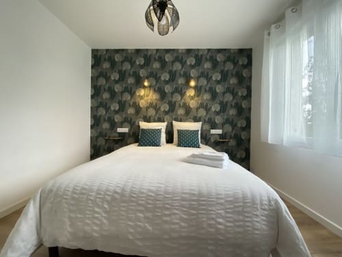 Chambre moderne à La Maison Blanche à Bouguenais avec mur d'accent à motifs, literie blanche et luminaires suspendus
